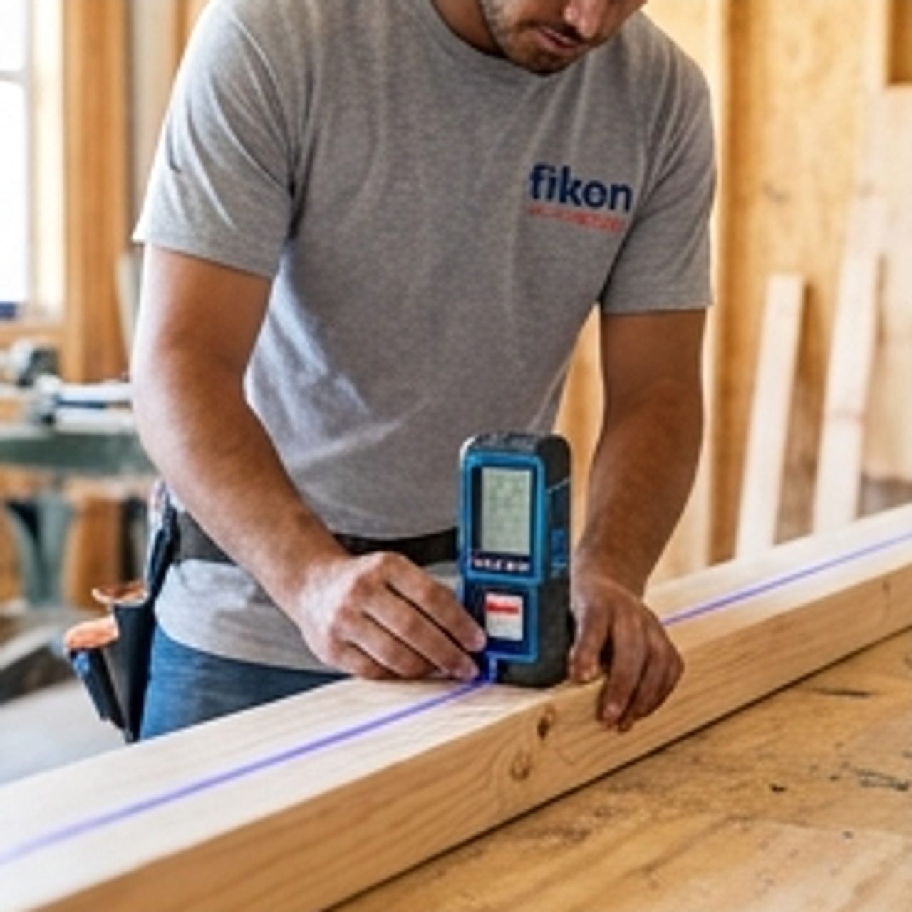 worker measuring lumber with precision tool